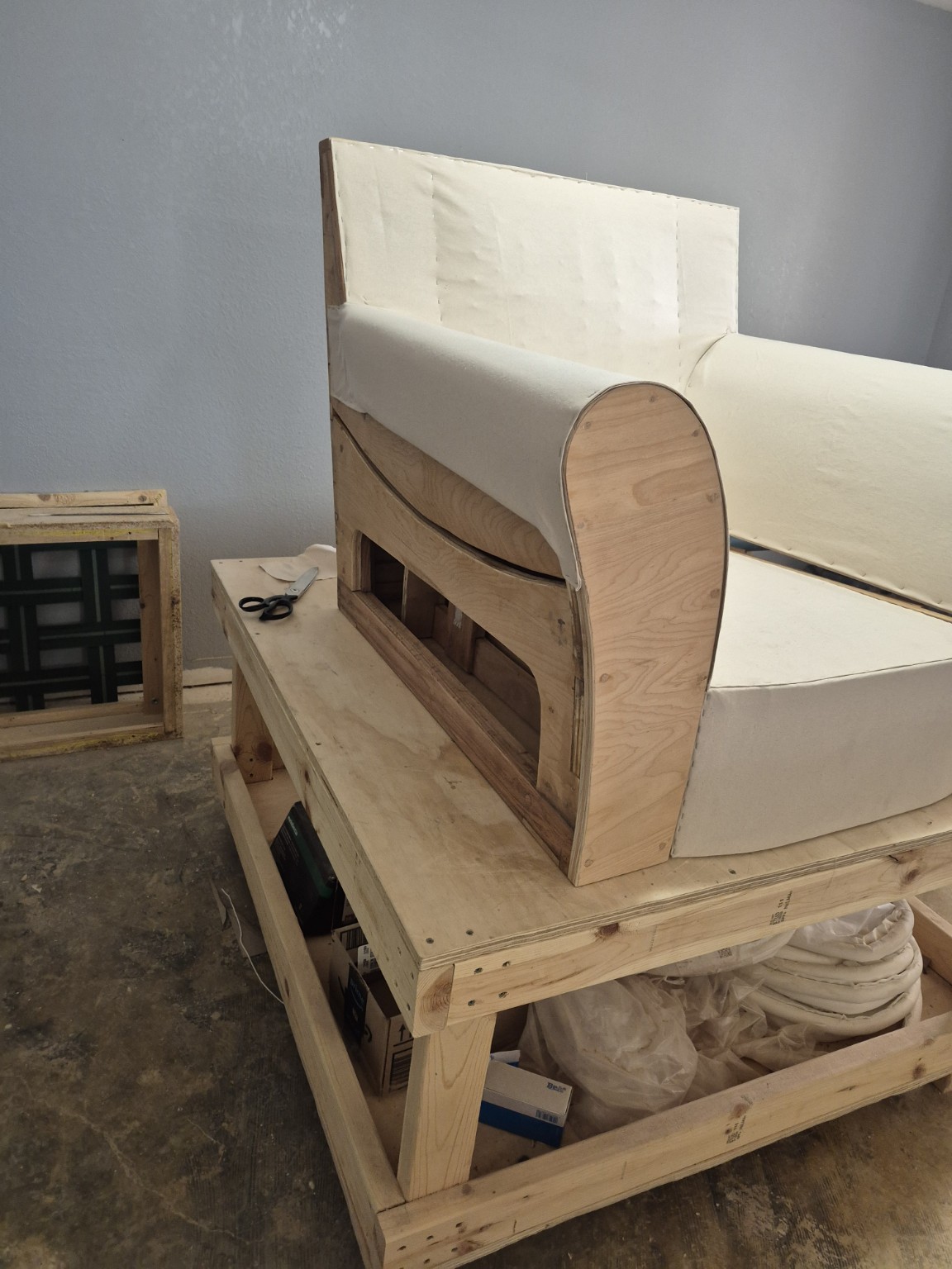 Rebuilt chair with initial light-colored covering layers over its arms and back