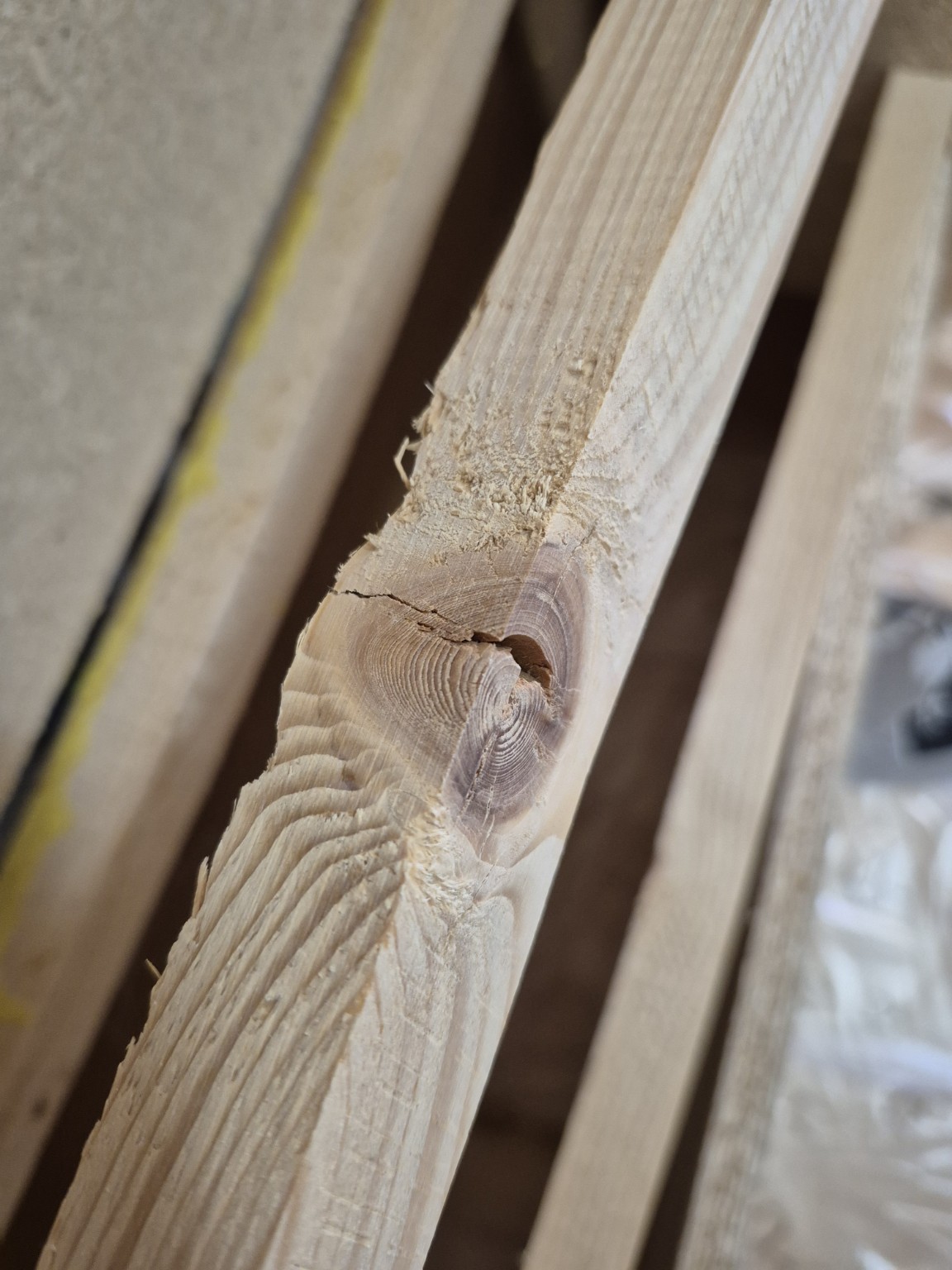 Close-up of a large cracked knot in the original right arm rail