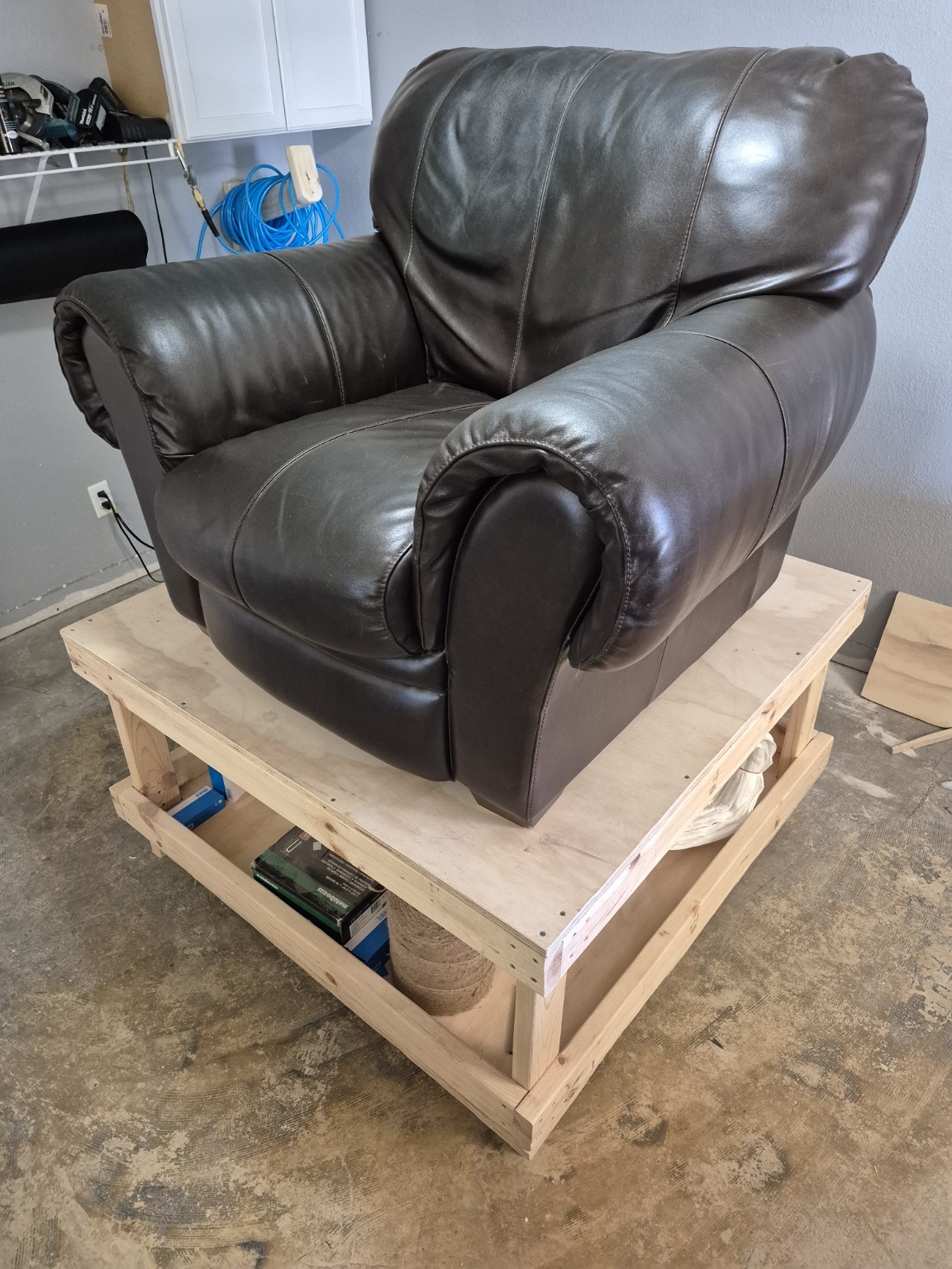 Leather-covered armchair before restoration, with a dark grease stain visible in the headrest area